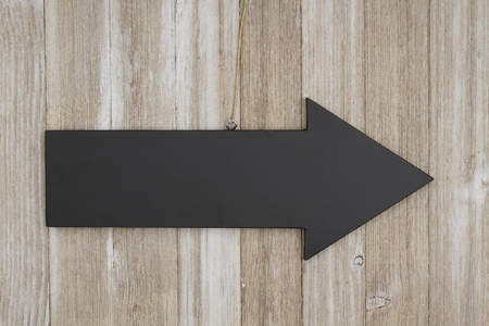 Arrow chalkboard sign on weathered wood with copy space for your messageの写真素材