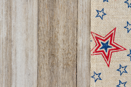 USA red and blue stars burlap ribbon on weathered wood background with copy space for your messageの写真素材