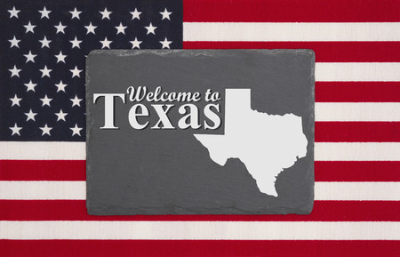Welcome to Texas with state map on a black chalkboard on a United States of America flag