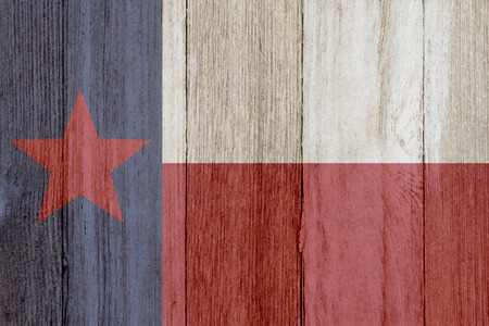 A rustic old Texas flag on weathered wood for a backgroundの写真素材