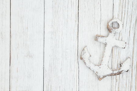 A anchor on weathered whitewash textured wood background with copy space for your messageの写真素材