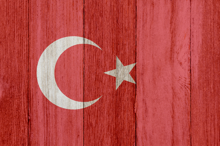 A rustic old Turkish flag on weathered wood for a backgroundの写真素材