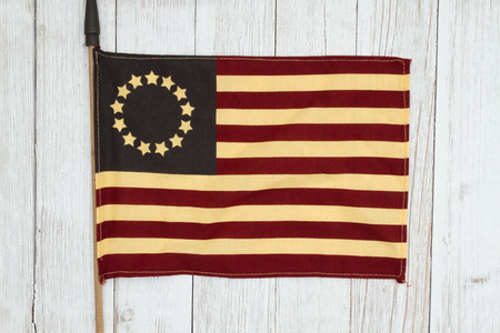 Red, white and blue retro American flag on weathered whitewash textured wood