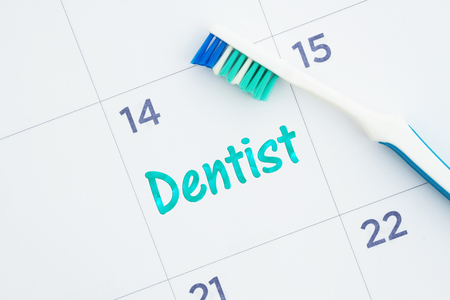 Schedule a dentist appointment message on a monthly calendar with a toothbrushの写真素材