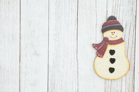 A snowman on weathered whitewash textured wood  with copy space for your messageの写真素材