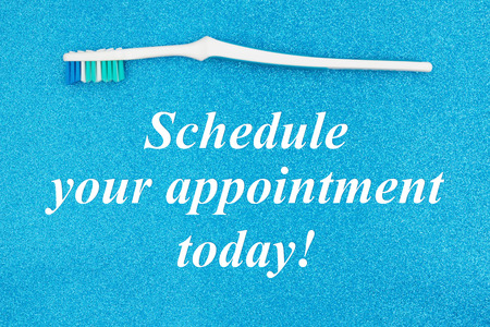 Schedule your appointment today text with toothbrush on a blue glitter paper for your healthcare messageの写真素材