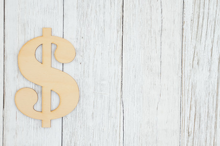 Wood dollar sign on weathered whitewash textured wood background with copy space for your message