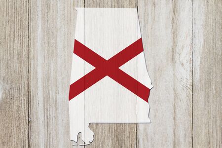 Map of Alabama in the Alabama flag colors on weathered woodの写真素材