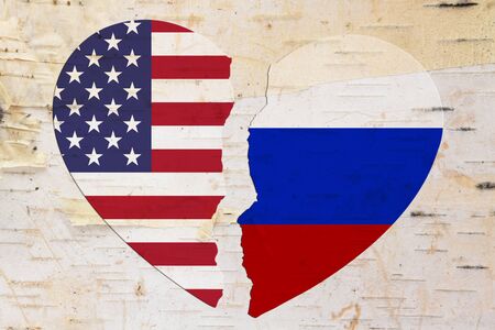 American and Russian flags in a broken heart over weathered woodの写真素材
