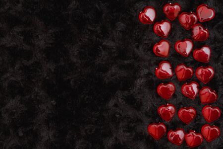 Red hearts on black rose textured plush fabric with copy space for your message