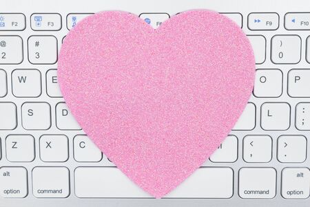 Close-up of a light gray computer keyboard with blank pink heart for your message