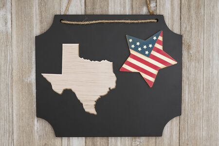 Wood map of the state of Texas, USA  on a chalkboard with patriotic USA red and blue star on weathered woodの写真素材