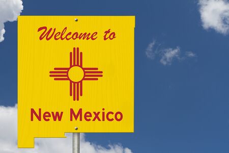 Welcome to the state of New Mexico road sign in the shape of the state map with the flag with skyの写真素材