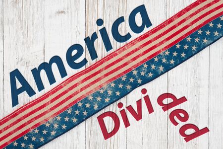 America Divided type message with retro USA stars and stripes burlap ribbon on weathered whitewash wood の写真素材