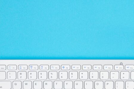 Gray keyboard on a blue background with copy space for your tech messageの写真素材