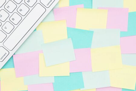 Sticky note background with multi-color notes with a keyboard and copy space for your office or...