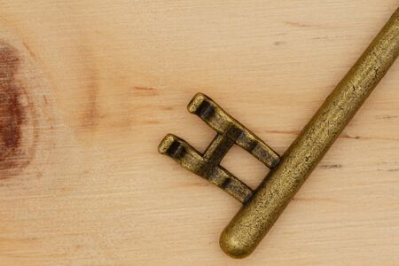 Close up of skeleton key on wood background with grain textureの写真素材