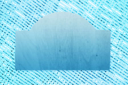 Blank blue wood sign on blue and white sparkle ribbon weave textured material with copy space for messageの写真素材