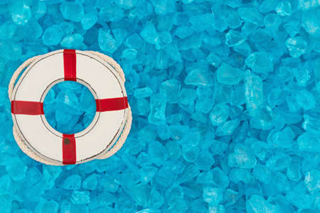 Whitewash life preserver on teal textured beach glass background with copy space for beach or...