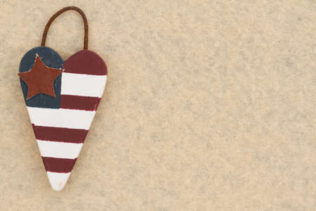 American background with retro USA stars and stripes flag wood heart on beige felt material with...