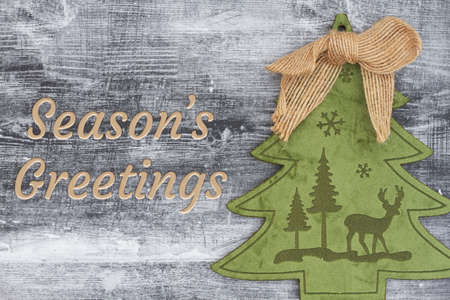 Seasonâ€™s Greeting message with Christmas tree with grunge wood background