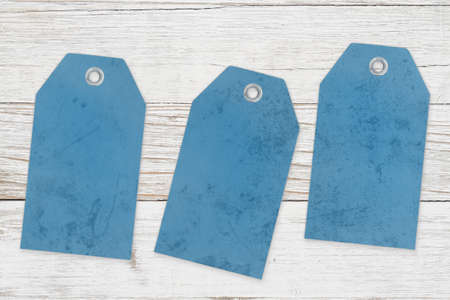 Three blank blue gift tags on weathered wood with copy space for your messageの写真素材