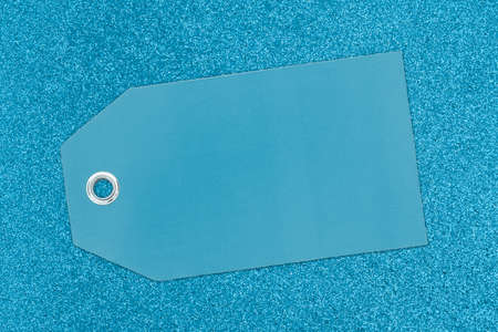 Blank teal gift tag on glitter paper with copy space for your message
