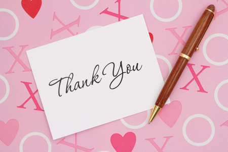 Thank You message on a greeting card with pen on pink love paperの写真素材