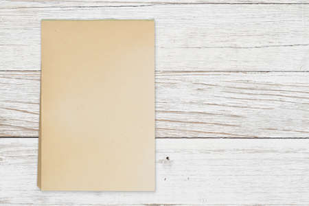 Blank retro old yellowed paper notepad on weathered wood