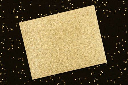 Blank gold glitter greeting card on black sparkle backgroundの写真素材