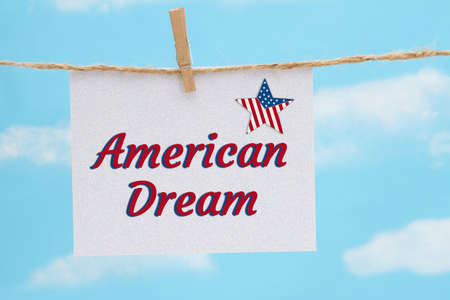 American Dream white greeting card with USA flag star over hanging clear blue skyの写真素材