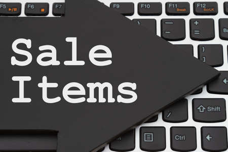 Sale Items message on chalkboard arrow on a black and silver keyboard