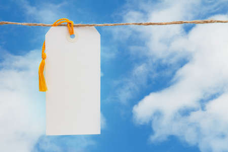 Blank white gift tag over sky with copy space for your messageの写真素材