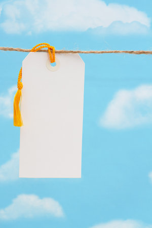 Blank white gift tag over sky with copy space for your messageの写真素材