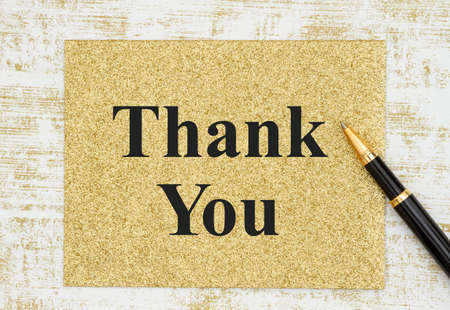 Thank you greeting card with pen on grunge gold and whiteの写真素材