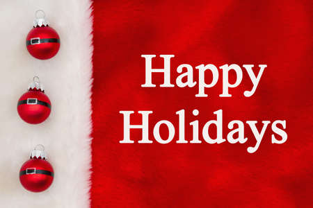 Happy Holidays greeting with ball ornaments on white and red plush materialの写真素材
