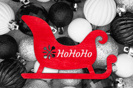 HoHoHo greeting with black and white ball ornaments and red Santa sleighの写真素材