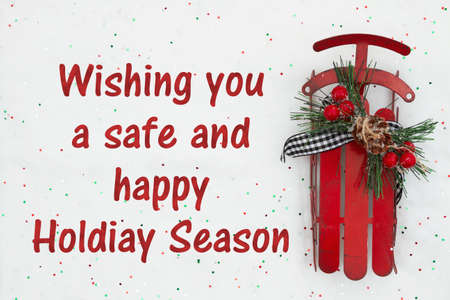 Wishing you a safe and happy Holiday Season message with red winter sled