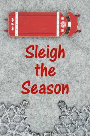 Sleigh the Season message with red and white winter sled on gray