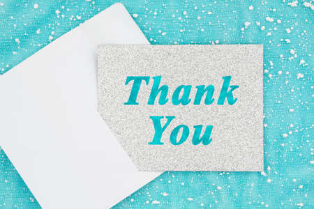 Thank you silver glitter greeting card with envelope on blue with snowflakesの写真素材