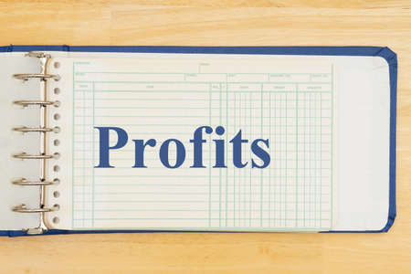 Making a profit with a paper ledger on a wood desk with debit, credit, and balanceの写真素材