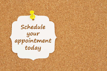 Schedule your appointment today message on gift tag on a bulletin boardの写真素材
