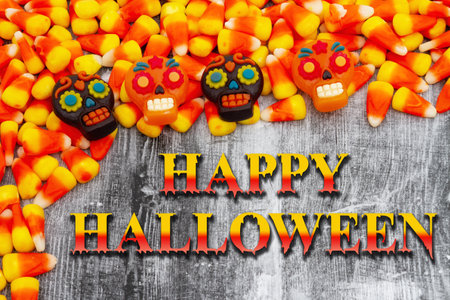Happy Halloween greeting with orange and yellow candy corn and skullsの写真素材