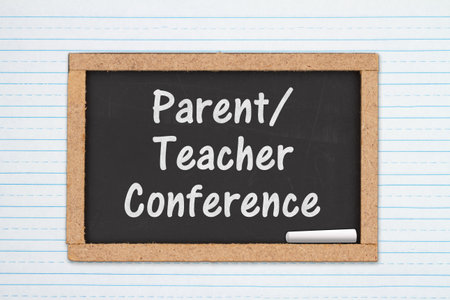 Parent Teacher Conference message on a chalkboard on white lined paperの写真素材