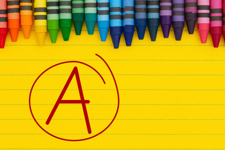 Getting a grade A message with crayons on bright yellow lined paperの写真素材