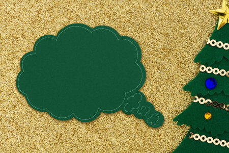 A speech bubble with a Christmas tree on gold glitter holiday paper for your Christmas or seasonal...
