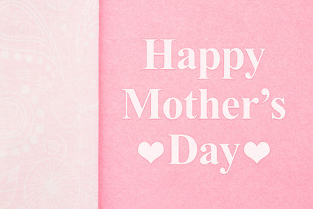 Happy Mothers Day greeting on pink with ribbon with swirlsの写真素材