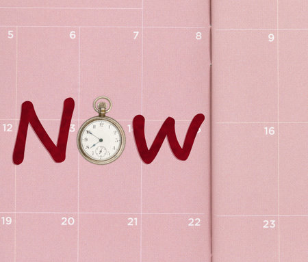 Now message on a pink calendar with old pocket watchの写真素材
