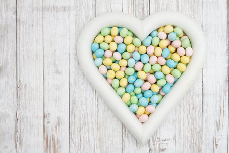 Easter egg in a heart on weathered wood for your holiday messageの写真素材