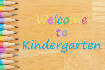 Welcome to Kindergarten message with pastel color pencils on wood desk for you education or school messageの写真素材